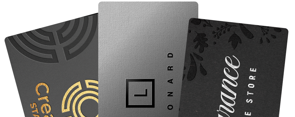 A fan of engraved cards in black, brushed silver and gold finishes